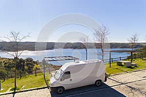 Camper van with solar panel drone aerial view in Odeleite dam reservoir landscape living van life on the countryside in Alentejo, photo
