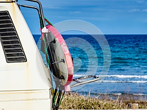 Camper van with surf board on beach