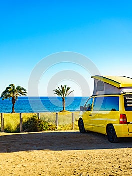 Camper van with tent on roof on beach