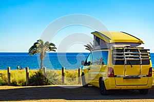 Camper van with tent on roof on beach