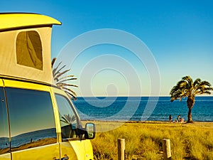 Camper van with tent on roof on beach