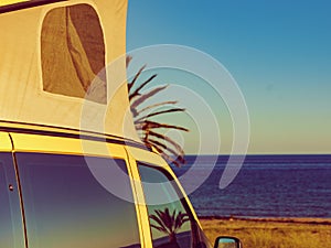 Camper van with tent on roof on beach