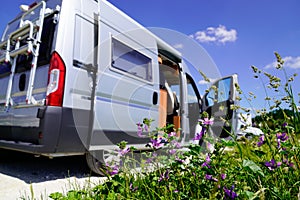 Camper van during vacation travel in RV holiday trip in motorhome with spring flowers