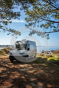 Camper van on a wild beach in Arousa island living van life in Galicia, Spain photo