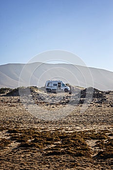 Campervan parking close to the beach. Free camping concept. Vanlife. Van in the nature.