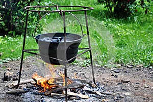 Campfire cooking in cauldron