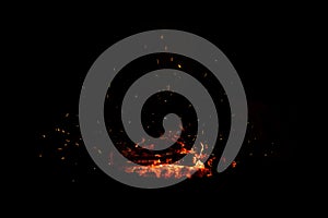 Campfire flame sparks isolated on black background. Fire flames heat energy heap in the night. Fire sparkles isolated on