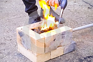 Campfire, lit between fireproof bricks for heating metal