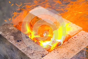 Campfire, lit between fireproof bricks for heating metal