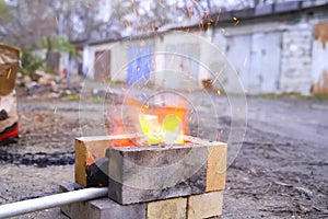 Campfire, lit between fireproof bricks for heating metal
