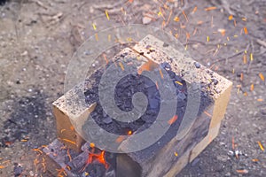 Campfire, lit between fireproof bricks for heating metal
