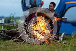 Campfire at touristic camp at nature in outdoor forest, flame and  fire sparks.  Group friend background