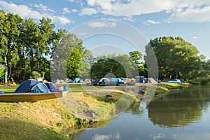 Camping area with tents near river