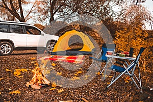 camping autumn place with bonfire and portable chairs