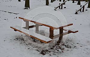 The camping bench in the snowy forest is a place where tourists and mothers with children can have a snack. if he cleans the table