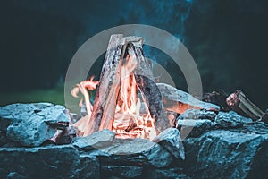 Camping bonfire with yellow and red flames in summer, forest. Copy space