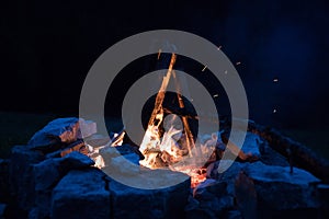 Camping bonfire with yellow and red flames in summer, forest. Copy space