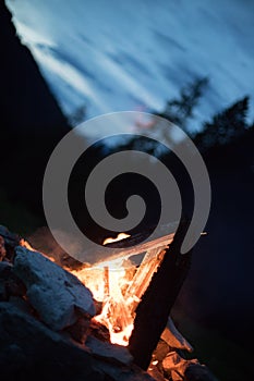 Camping bonfire with yellow and red flames in summer, forest. Copy space