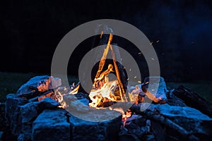 Camping bonfire with yellow and red flames in summer, forest. Copy space photo