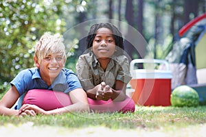 Camping, children and relaxing in portrait on grass, bonding and happy for outdoor adventure. Kids, face and smiling