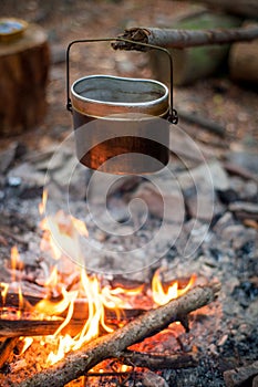 Camping cooking on a campfire outdoor, tourist kettle.