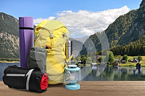 Camping equipment for tourist on wooden surface and beautiful view of mountain landscape