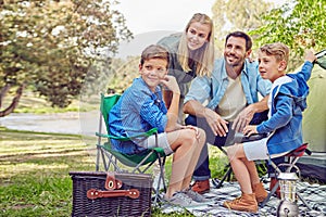 Camping is a family pasttime. a family of four camping in the woods. photo