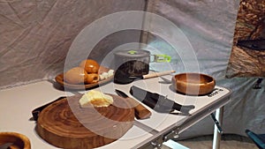 Camping food on a folding table with wooden dishes