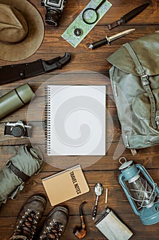 Camping gear including knife, clothes, boots, lantern, camera, hat, map, compass. Vertical wanderlust, safari postcard, poster,