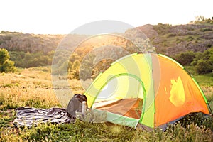 Camping gear and tourist tent in wilderness