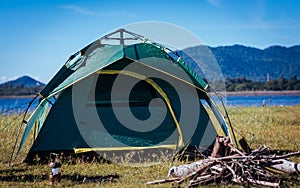 Camping green tent near lake