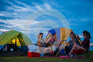 Camping of happy asian young travellers at lake photo