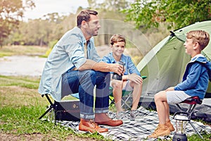 Camping with his boys. a father and his two sons out camping in the woods.