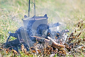 Camping kitchenware - pot on the fire at an outdoor campsite