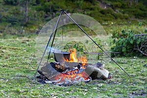 Camping kitchenware - pot on the fire at an outdoor campsite