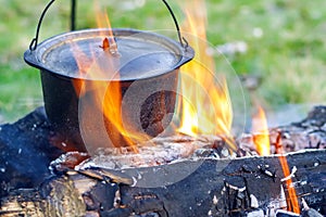 Camping kitchenware - pot on the fire at an outdoor campsite