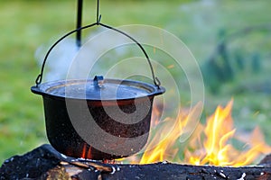 Camping kitchenware - pot on the fire at an outdoor campsite