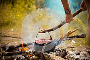 Camping kitchenware - pot on the fire at an outdoor campsite.