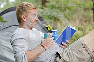 camping man reading traveling guild book