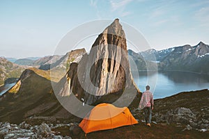Camping in mountains man with tent in Norway travel adventure