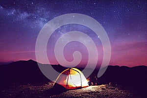 Camping in the mountains in a tent under the glowing stars and the Milky Way, generative ai