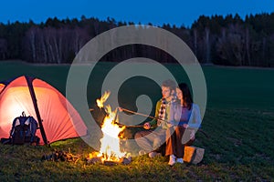 Camping night couple cook by campfire romantic