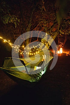 Camping in Night Forest With Sparklers. Woman Lying In Hammock