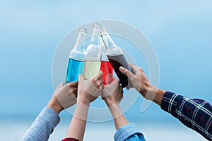 Camping outdoor. Close up hand holding bottle alcohol for group friends drinking and camping leisure