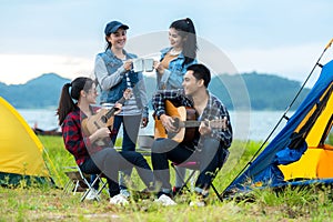 Camping outdoor. Group  friends camping leisure and destination travel. Family sitting around camp fire and playing guitar and roa
