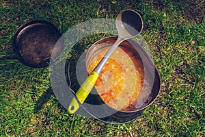 Camping pot with mouthwatering soup meal. Outdoor stew food. Wildlife lifestyle cooking delicious meal. Eat outside. Copyspace