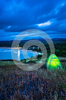 Camping solo at mountain top with amazing view and dramatic sky at evening