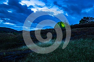 Camping solo at mountain top with amazing view and dramatic sky at evening