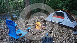 Camping tent in the Blue Ridge Mountains in Asheville, North Carolina. Outdoor lifestyle with axe, cast iron skillet, flannel blan