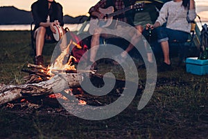 Camping tent camp in nature happy friends group night party bonfire and playing guitar together
